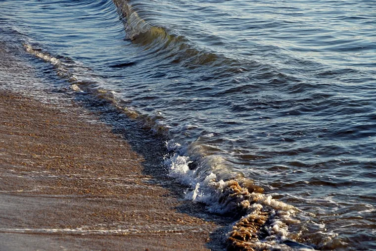 Une vague qui monte sur le sable, puis redescend (photo d'ambiance)