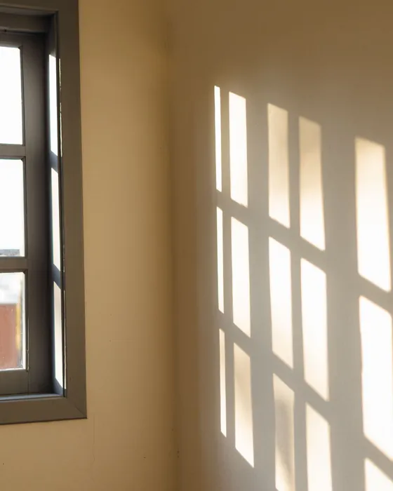 Image d'ambiance : la lumière du matin qui dessine une fenêtre sur le mur d'une chambre